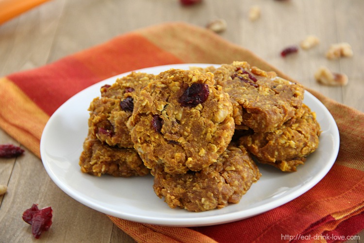 Pumpkin Breakfast Cookies stacked on a plate with dried cranberries