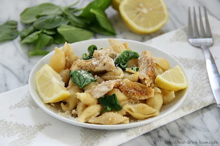 Lemony Chicken Pasta on a white plate with lemon slices