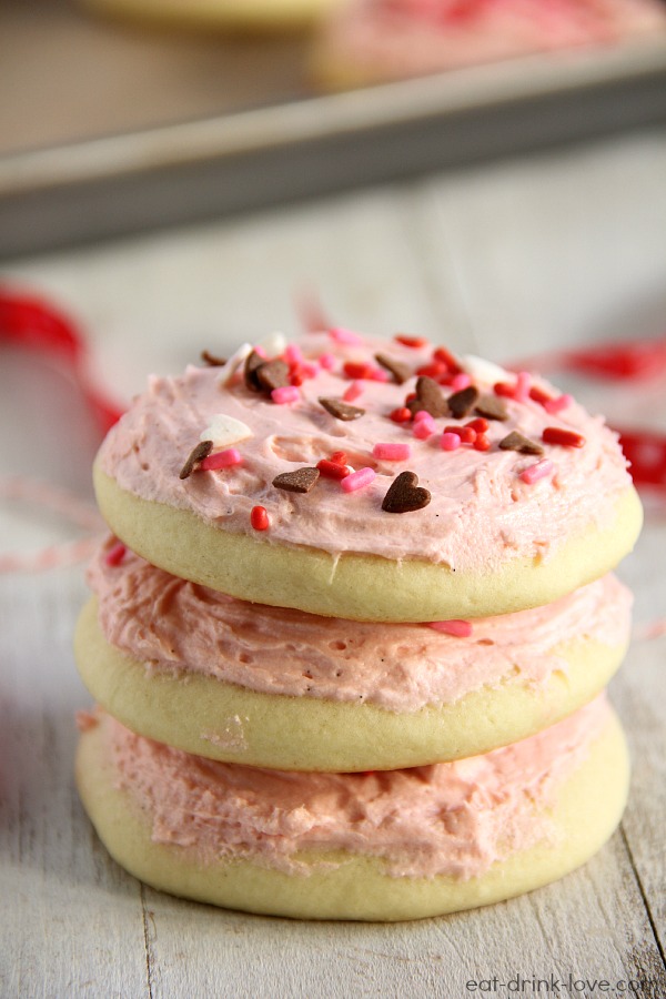 Sugar Cookies with Vanilla Bean Frosting - stacked sugar cookies with pink frosting and heart sprinkles