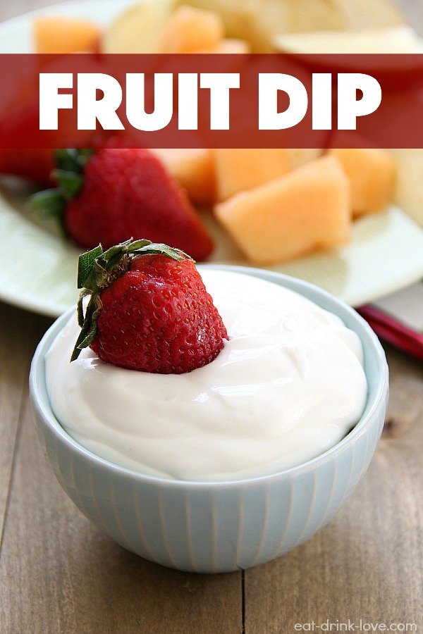 white fruit dip in a blue bowl with strawberries and cantaloupe