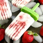 swirled strawberry coconut popsicles on top of ice