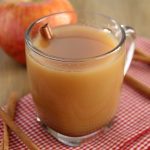 Spiced Apple Cider in a glass mug on a red checkered napkin