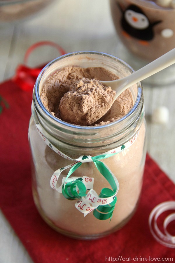 Hot Cocoa mix in a glass jar with a spoon on red napkin with a green ribbon