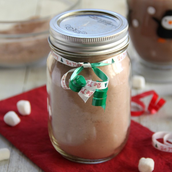 Hot Cocoa mix in a glass jar on red napkin with a green ribbon