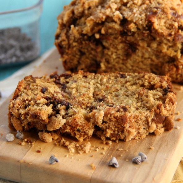 Chocolate Chip Banana Bread with Streusel Topping sliced on a wooden board