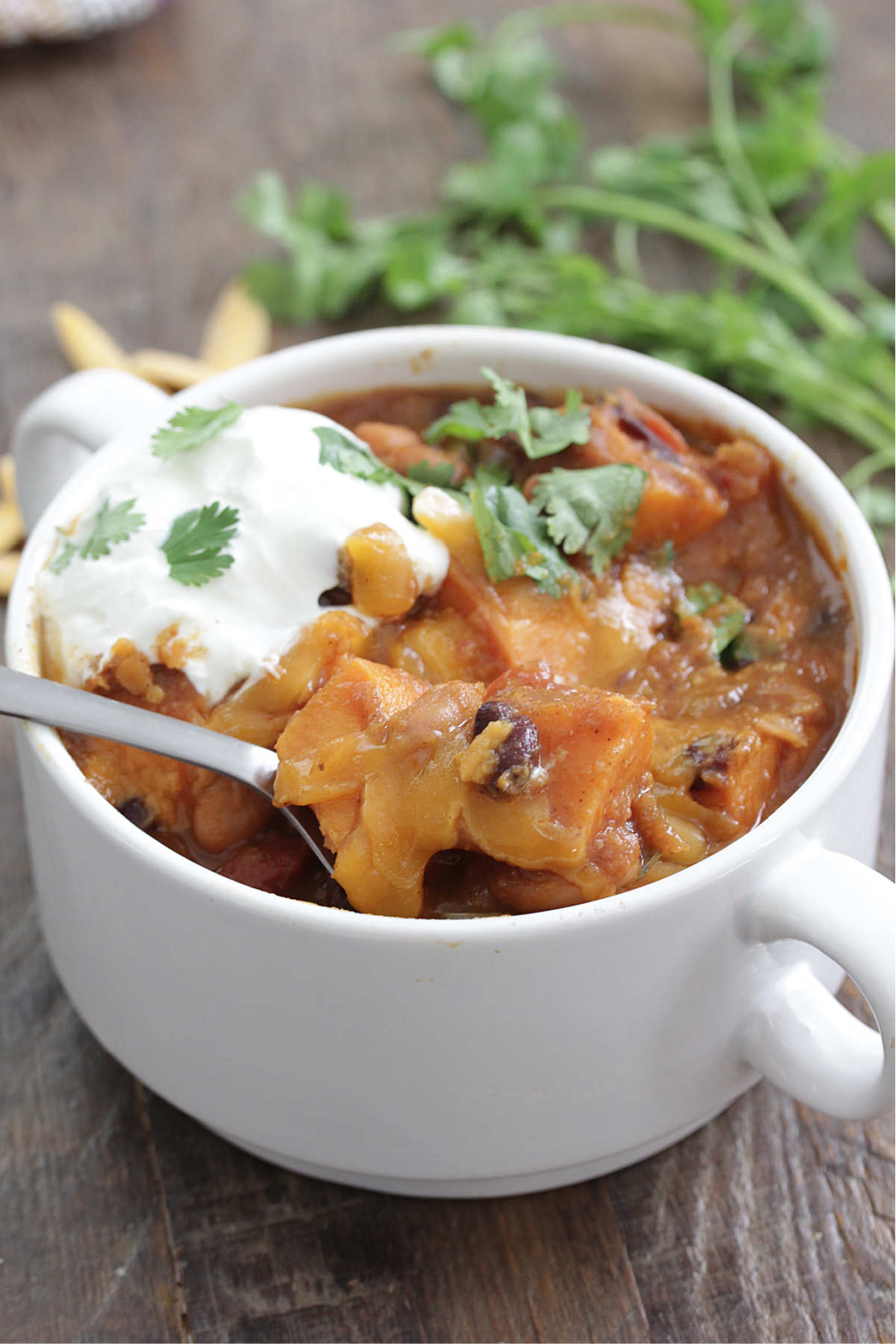 Sweet Potato Pumpkin Chili in a white bowl with cheese and cilantro