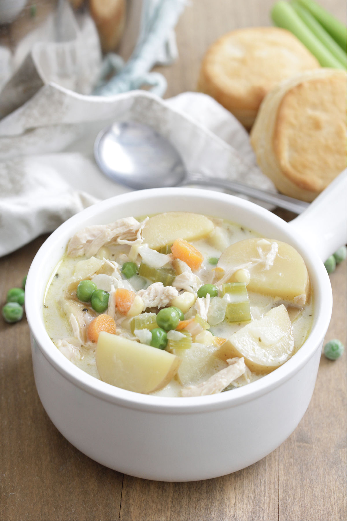 Chicken Pot Pie Soup in a white bowl with biscuits