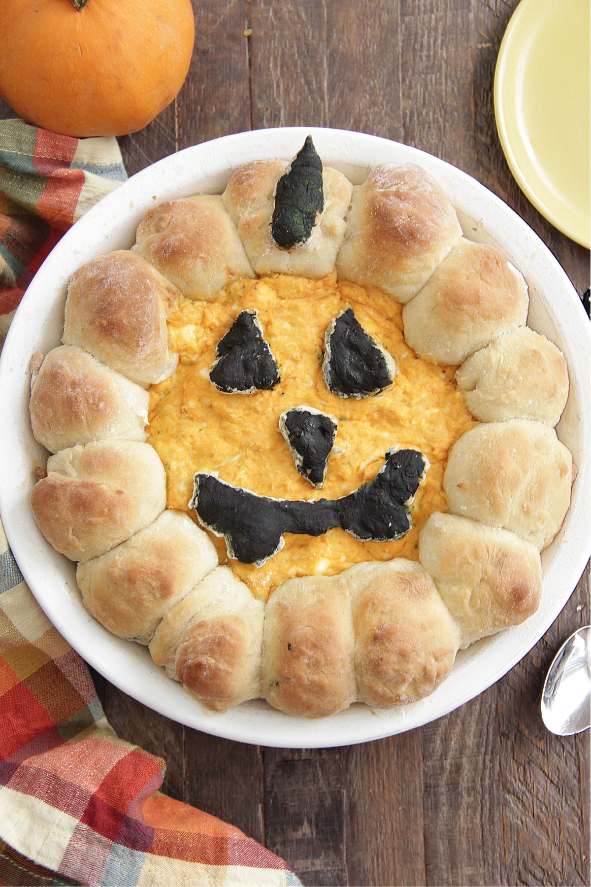 Halloween Buffalo Chicken Dip in a pie dish with jack-o-lantern face