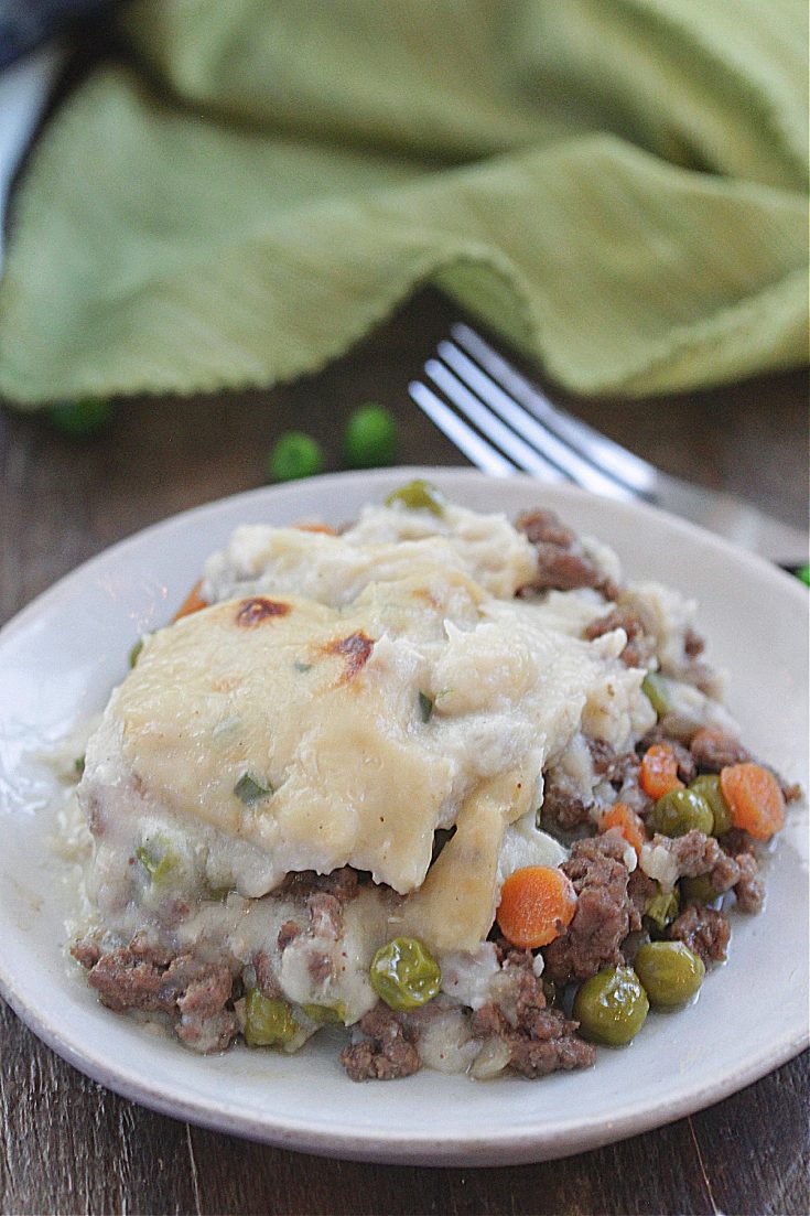 Low-Carb Shepard's Pie on a plate with cauliflower topping, beef, carrots, and peas