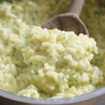 Cheesy Zucchini Rice scooped with a wooden spoon