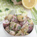 Lemon Herb Potato Salad - fingerling potatoes with creamy dressing in a bowl with a lemon and chives
