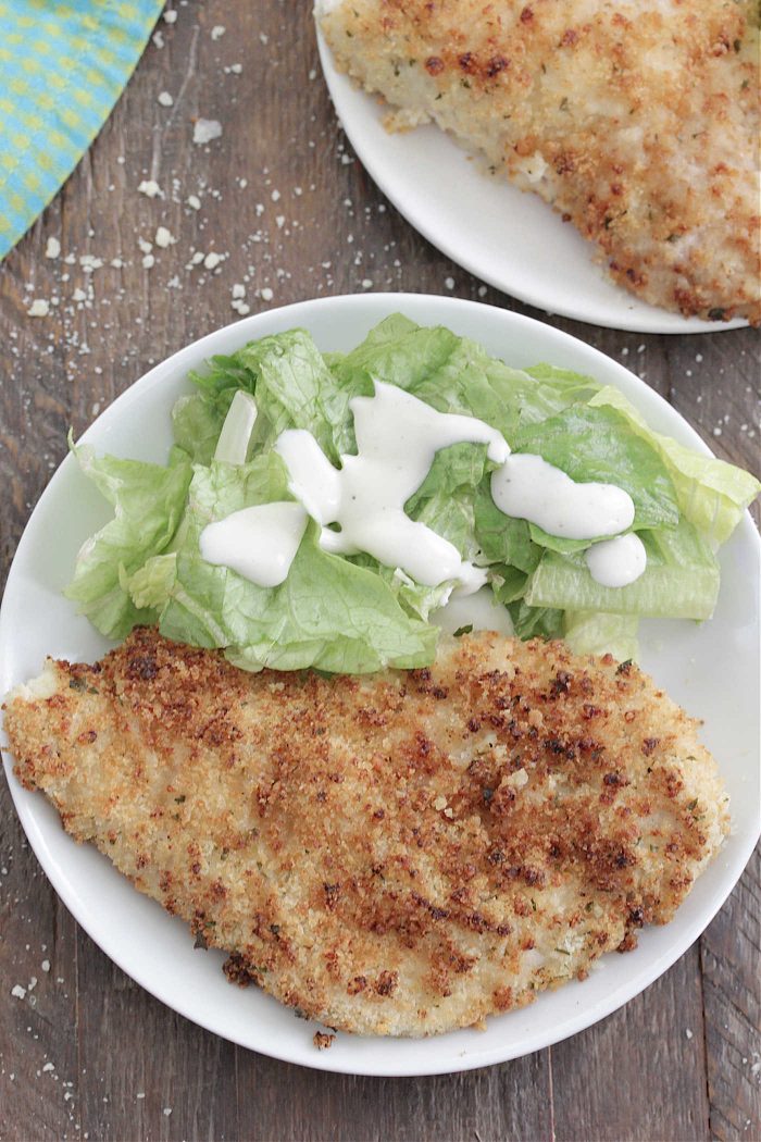 Baked Ranch Chicken overhead shot on a plate with salad with ranch dressing