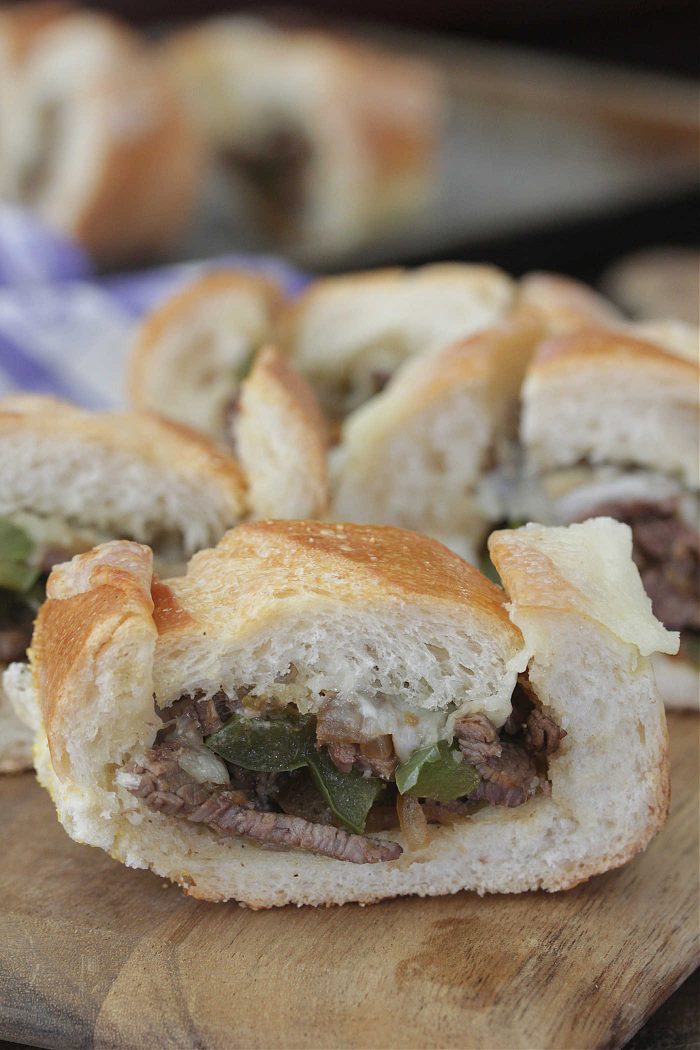 Philly Cheesesteak Stuffed French Bread on a wooden board