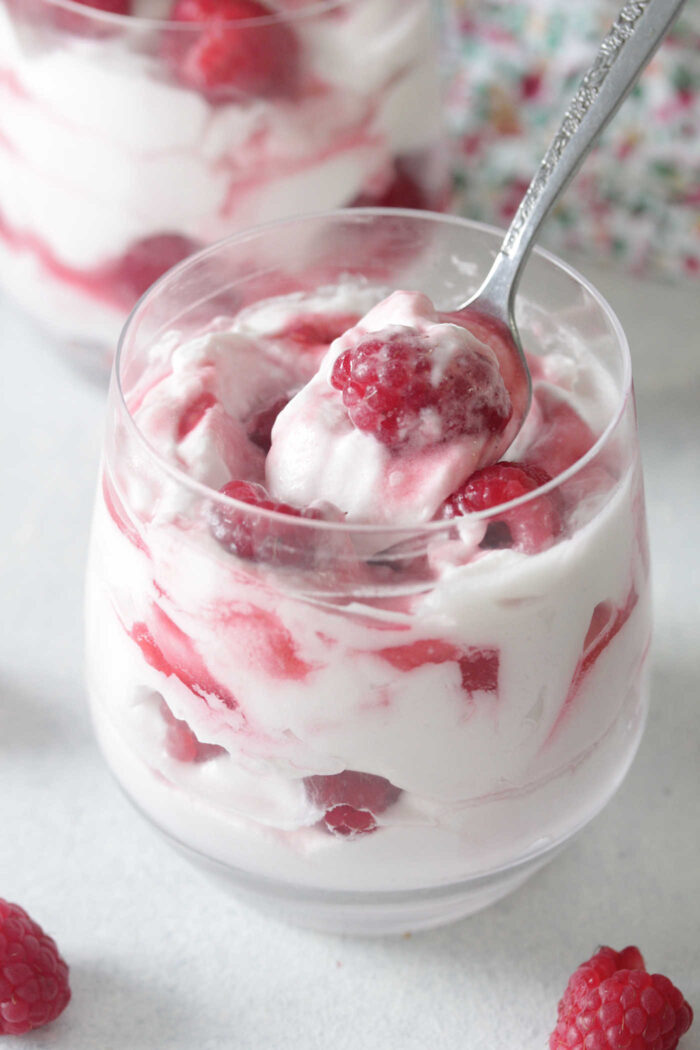 whipped cream and raspberries with a spoon