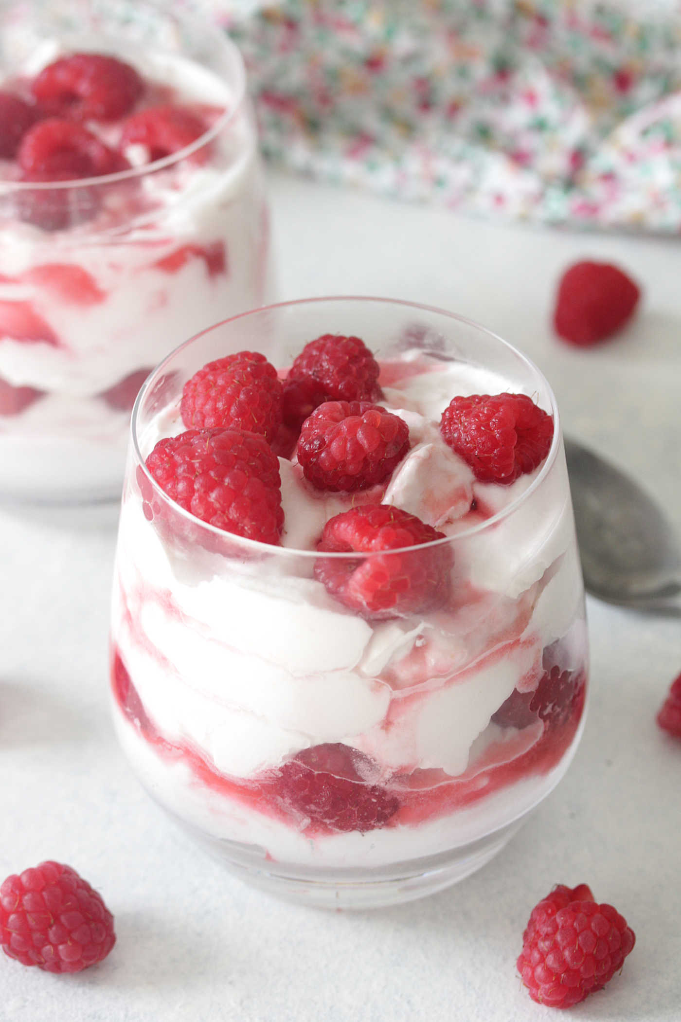 whipped cream and raspberries in a glass with raspberries on top
