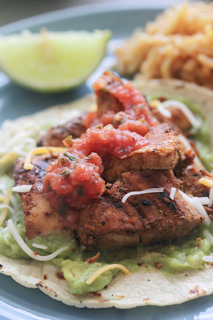 Adobo Lime Chicken on a taco shell with guacamole and salsa