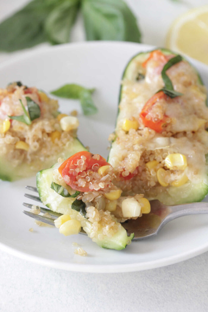 Corn and Tomato Stuffed Zucchini Boats cut up with a fork