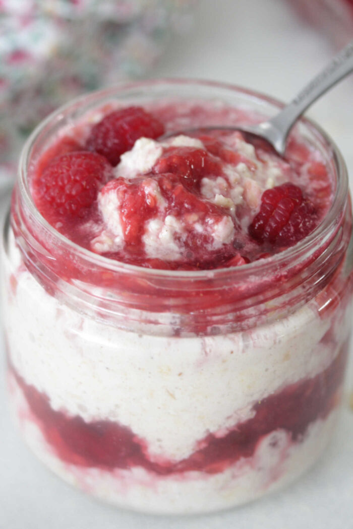 Raspberry Cheesecake Overnight Oats close-up photo with spoon