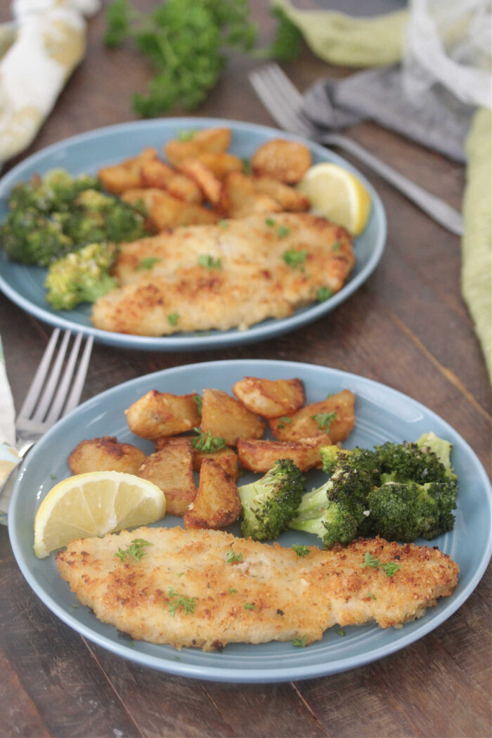 Plates of Sheet Pan Crispy Lemon Chicken with broccoli and potatoes