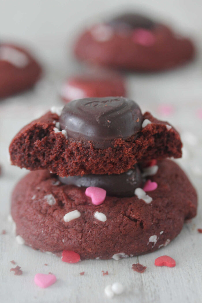 Red velvet cookie with chocolate heart on top with a bite taken out of it