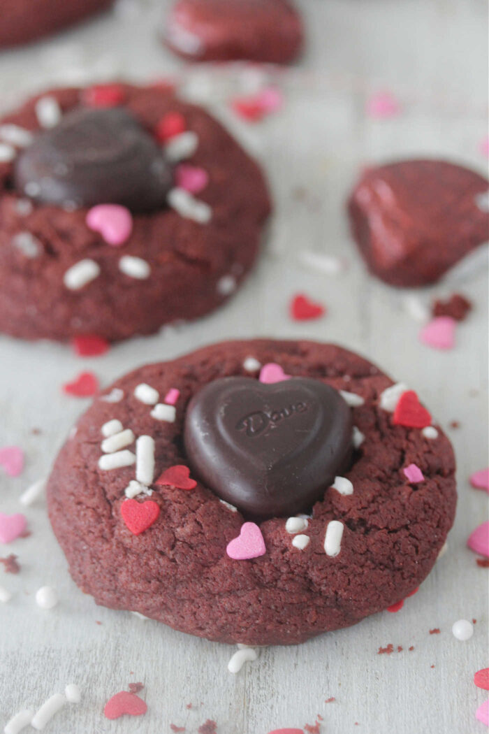 Red velvet cookies with heart-shaped chocolate and pink and red sprinkles on top