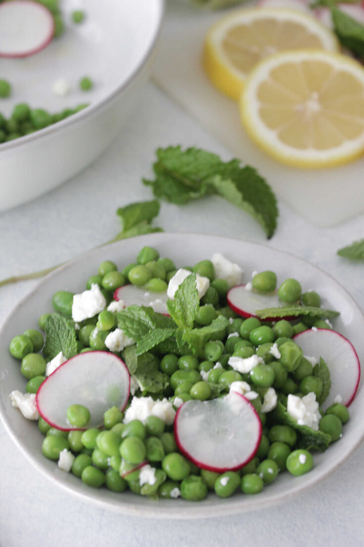 Spring Pea, Mint, & Feta Salad with sliced radishes on a white plate