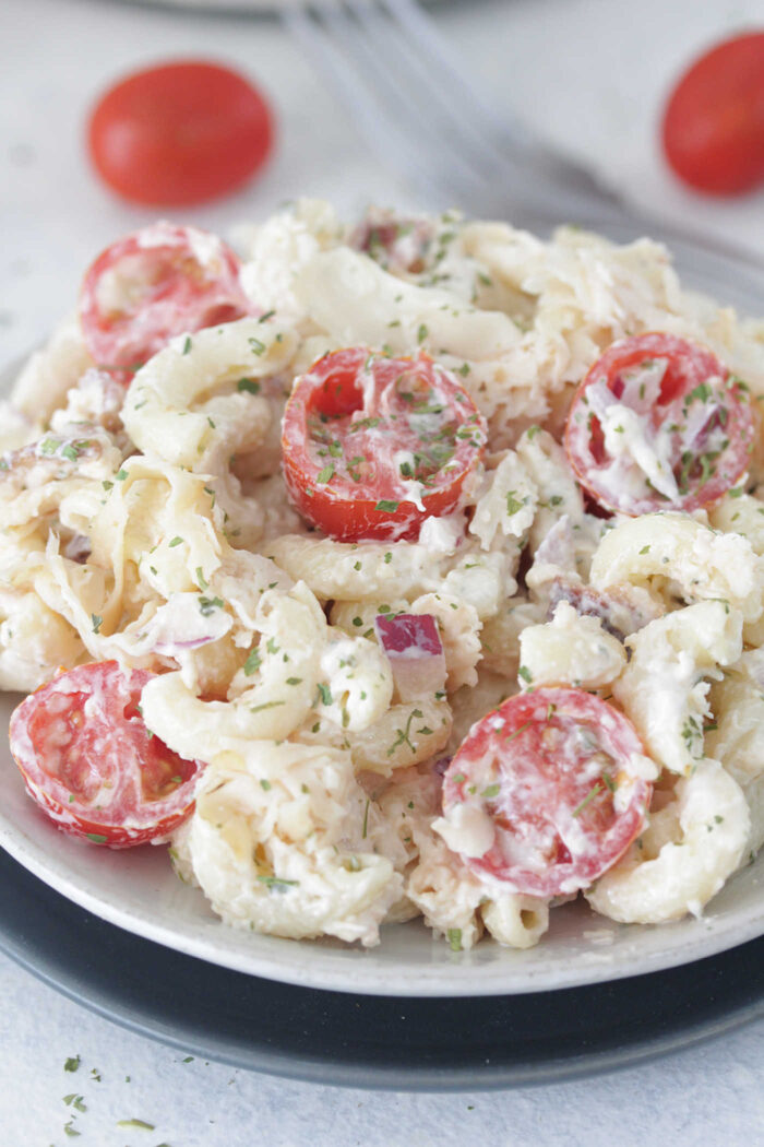 Close up photo of turkey club pasta salad with sliced grape tomoatoes