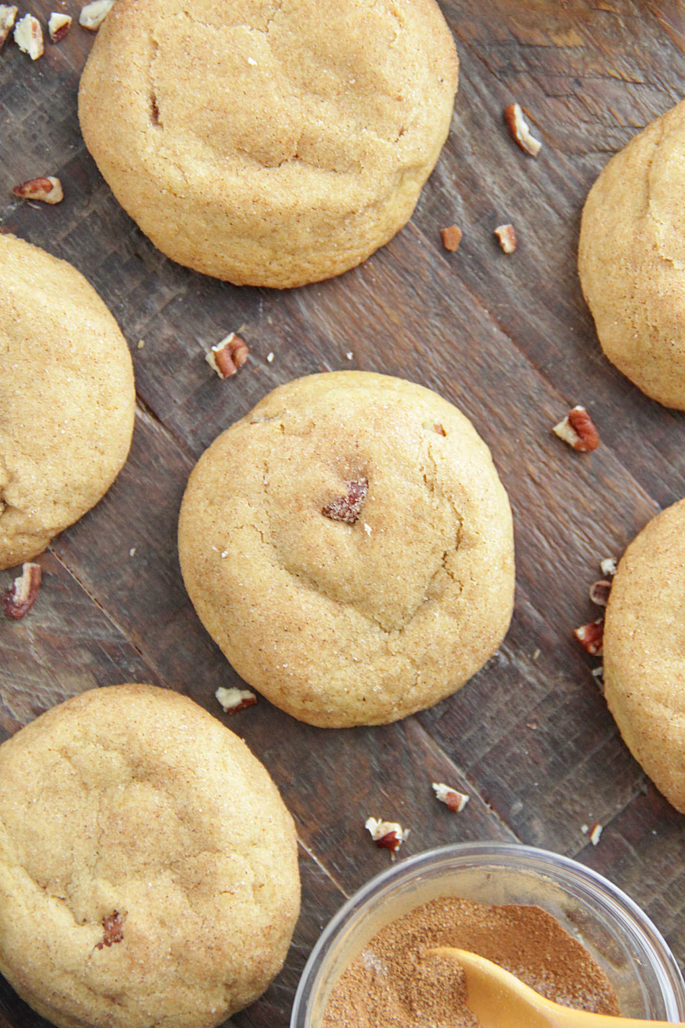 Overhead photo of brown butter maple pecan cookies on a dark wooden board