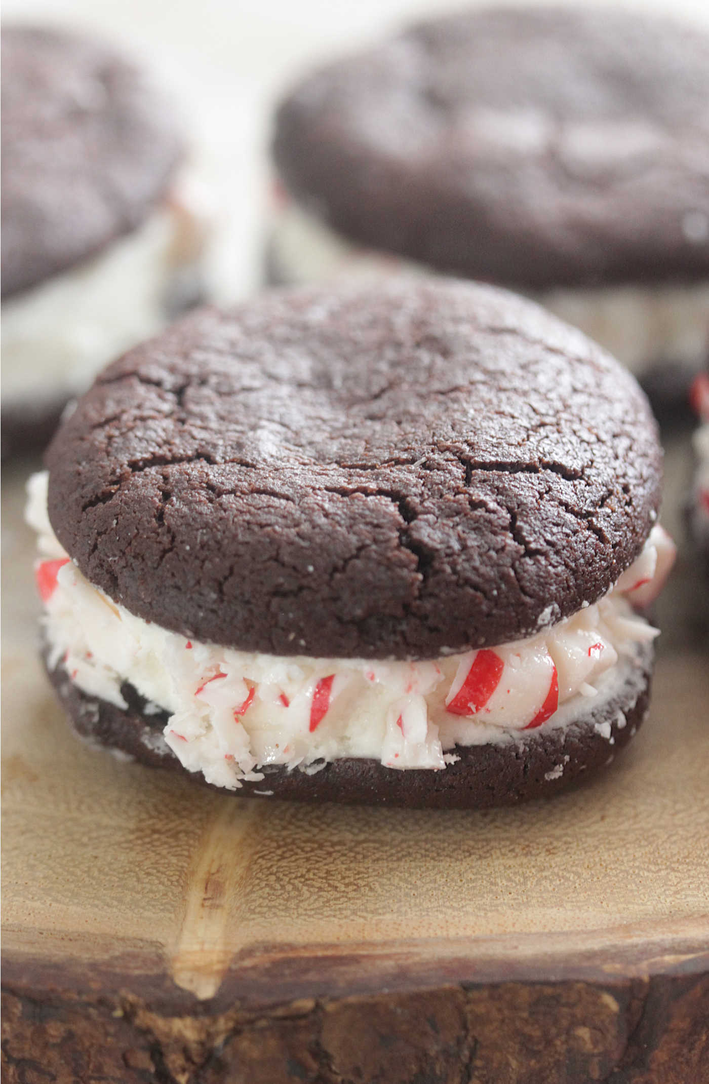 Chocolate Peppermint Sandwich Cookie on a wooden board rolled in crushed peppermint candies