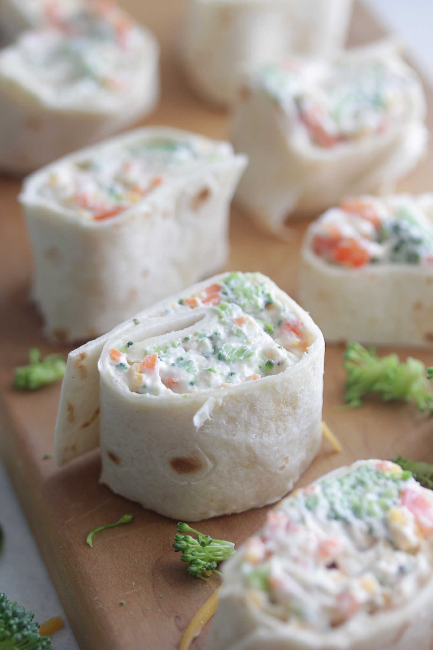 Veggie pinwheels wrapped in a flour tortilla and shredded broccoli
